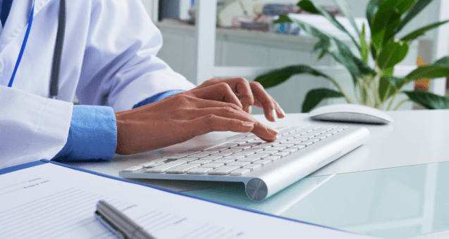 Doctor entering clinical data on a keyboard